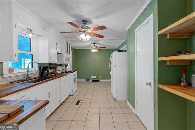 kitchen featuring sink, white cabinets, light tile patterned flooring, and white appliances