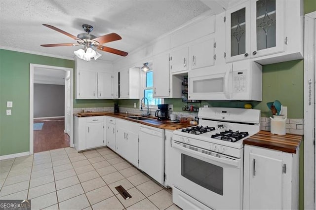 kitchen with wooden counters, white appliances, white cabinetry, and sink