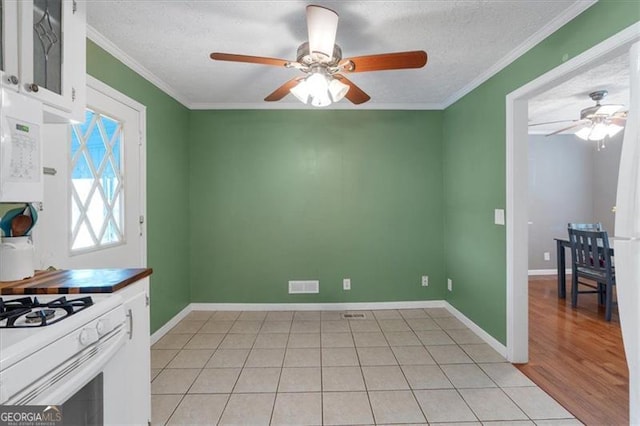 kitchen with crown molding, light hardwood / wood-style flooring, white cabinets, and a textured ceiling