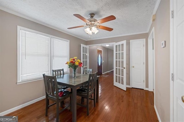 dining space with french doors, dark hardwood / wood-style floors, ceiling fan, ornamental molding, and a textured ceiling