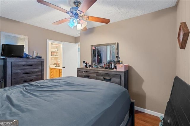 bedroom featuring hardwood / wood-style floors, ceiling fan, and a textured ceiling