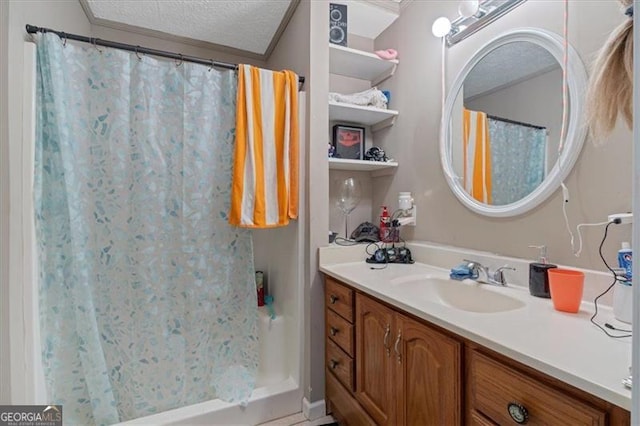 bathroom with a shower with curtain, vanity, ornamental molding, and a textured ceiling