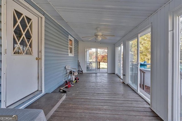 unfurnished sunroom featuring ceiling fan