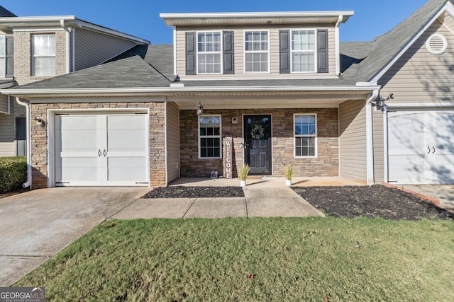 view of front of property featuring a porch, a front yard, and a garage