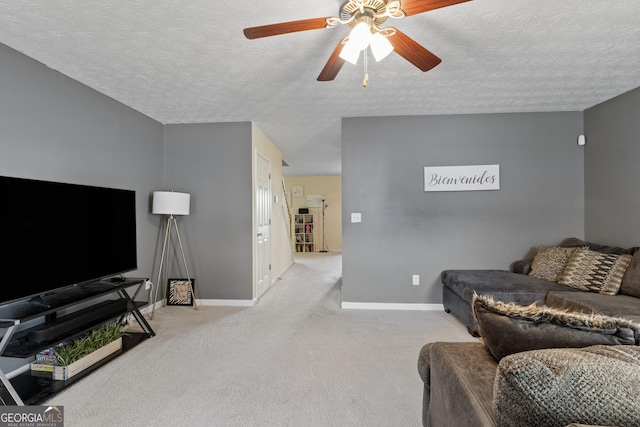 carpeted living room with a textured ceiling and ceiling fan