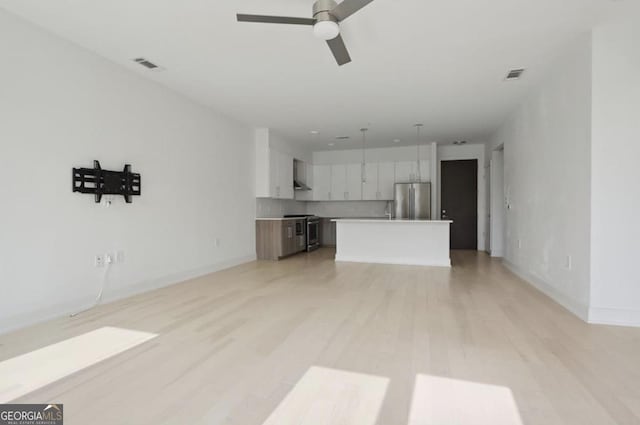 unfurnished living room featuring ceiling fan and light hardwood / wood-style floors