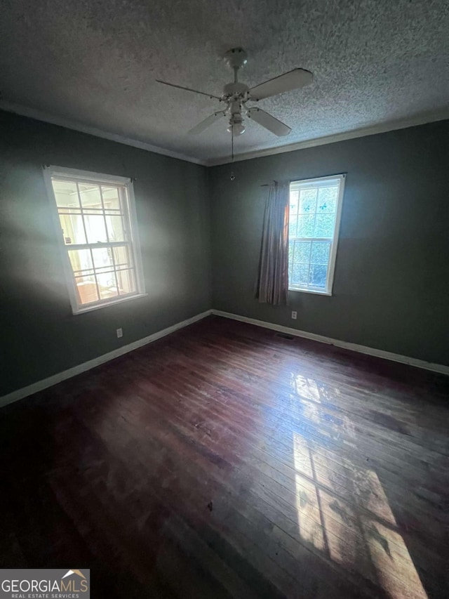 unfurnished room featuring a textured ceiling, crown molding, ceiling fan, and dark wood-type flooring