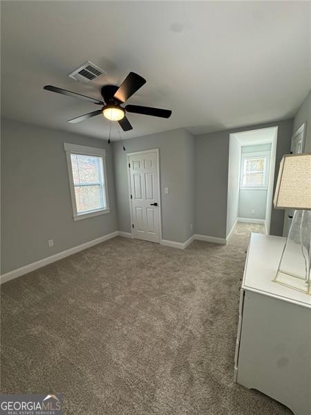 empty room featuring carpet flooring and ceiling fan