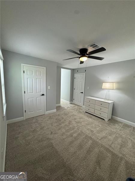 unfurnished bedroom with light colored carpet and ceiling fan