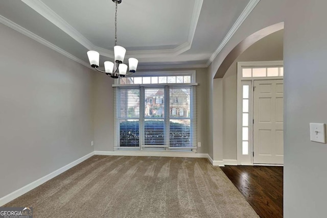 entrance foyer featuring a chandelier, hardwood / wood-style floors, a raised ceiling, and crown molding