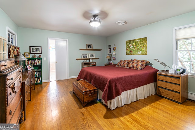 bedroom with wood-type flooring and ensuite bath