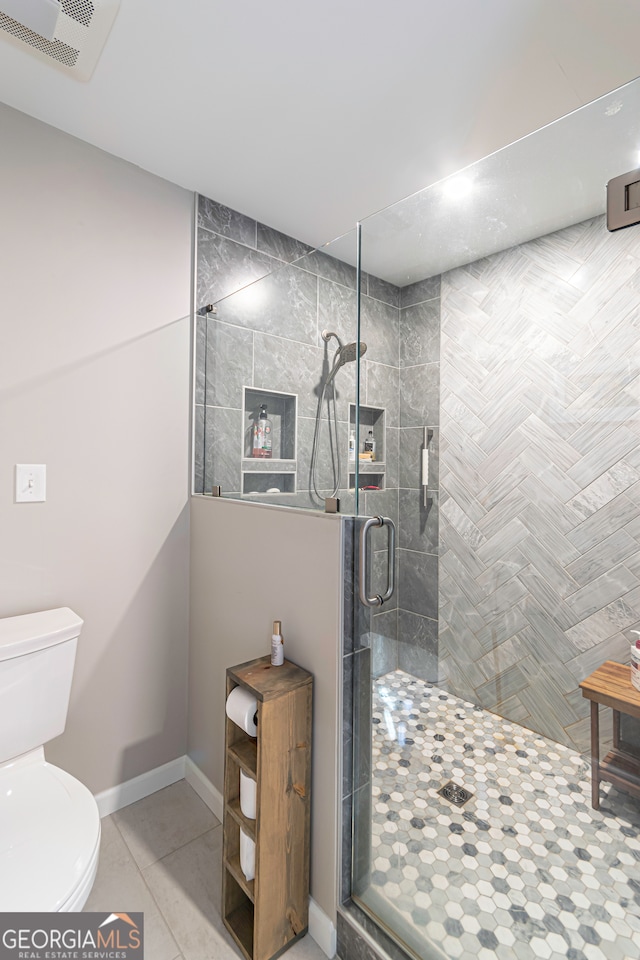 bathroom with tile patterned flooring, toilet, and walk in shower