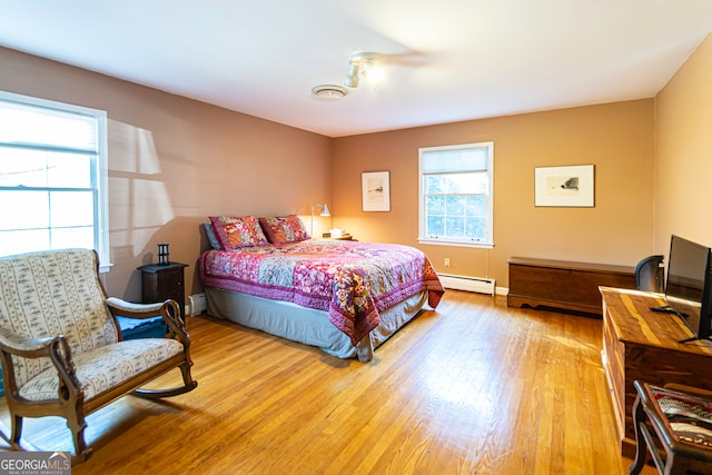 bedroom featuring hardwood / wood-style floors and a baseboard radiator