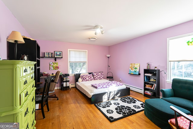 bedroom featuring hardwood / wood-style floors and a baseboard radiator