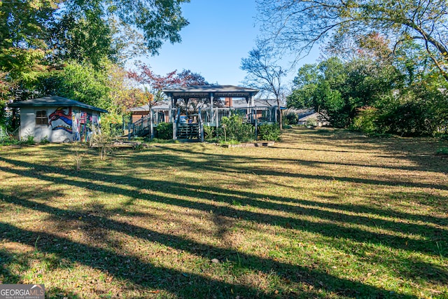 view of yard featuring a gazebo, a storage shed, and a wooden deck