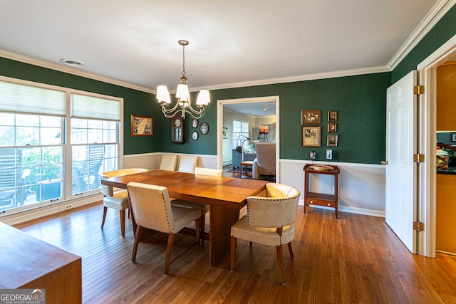 dining room with crown molding, an inviting chandelier, and hardwood / wood-style flooring