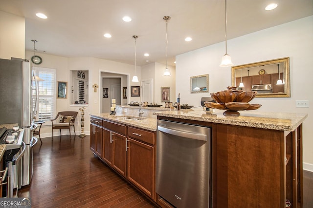 kitchen with pendant lighting, light stone counters, sink, and appliances with stainless steel finishes