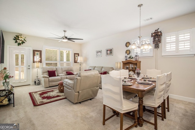 dining room featuring ceiling fan with notable chandelier and light carpet