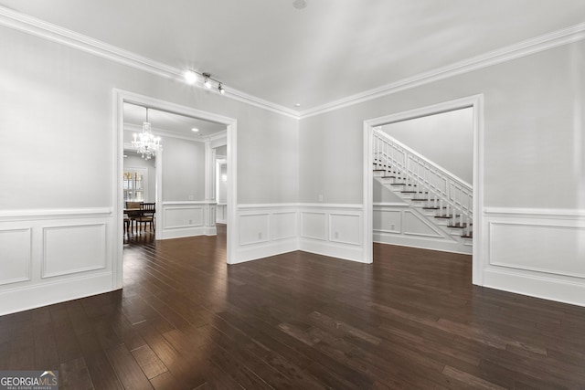 empty room with a chandelier, dark hardwood / wood-style flooring, and crown molding