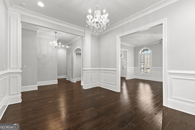 unfurnished dining area with dark wood-type flooring, ceiling fan with notable chandelier, and ornamental molding