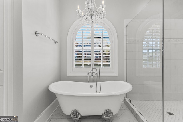 bathroom featuring separate shower and tub and an inviting chandelier