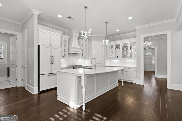 kitchen with white cabinetry, paneled refrigerator, dark hardwood / wood-style floors, a kitchen island with sink, and custom range hood