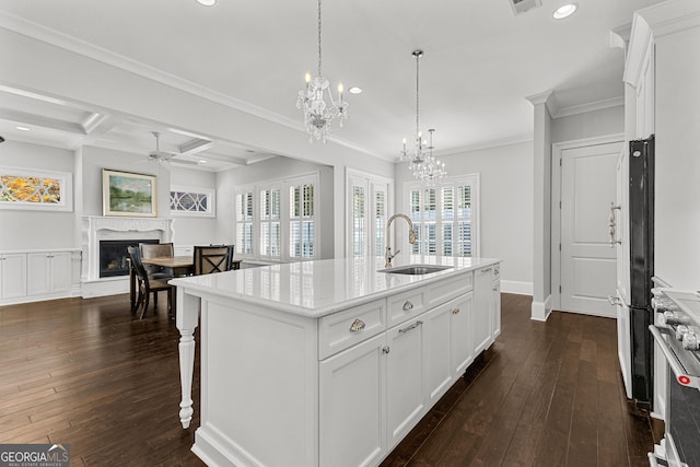 kitchen featuring white cabinetry, a center island with sink, and a healthy amount of sunlight