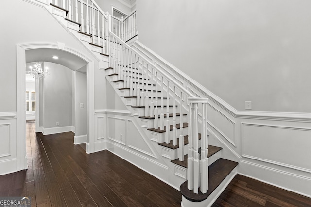 stairway featuring hardwood / wood-style floors and a chandelier