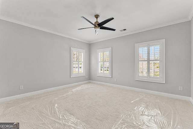 carpeted empty room with plenty of natural light, ceiling fan, and ornamental molding