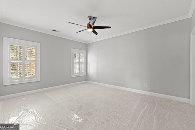 spare room with a healthy amount of sunlight, light colored carpet, and ornamental molding