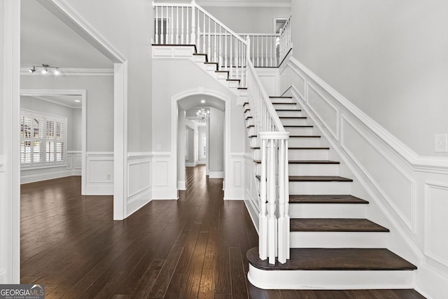 stairway featuring wood-type flooring and crown molding