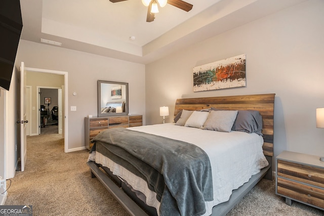 bedroom featuring carpet flooring, a raised ceiling, and ceiling fan