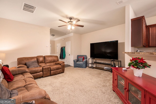 living room featuring ceiling fan, light colored carpet, and crown molding