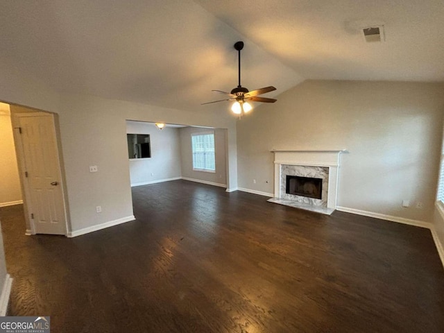 unfurnished living room featuring ceiling fan, a fireplace, lofted ceiling, and dark wood-type flooring