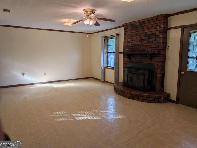 unfurnished living room featuring a wood stove, a wealth of natural light, crown molding, and ceiling fan