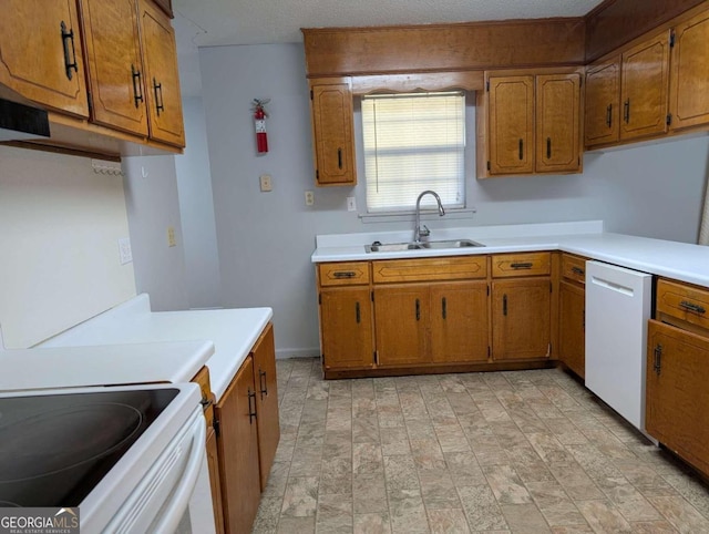 kitchen with a textured ceiling, white appliances, and sink