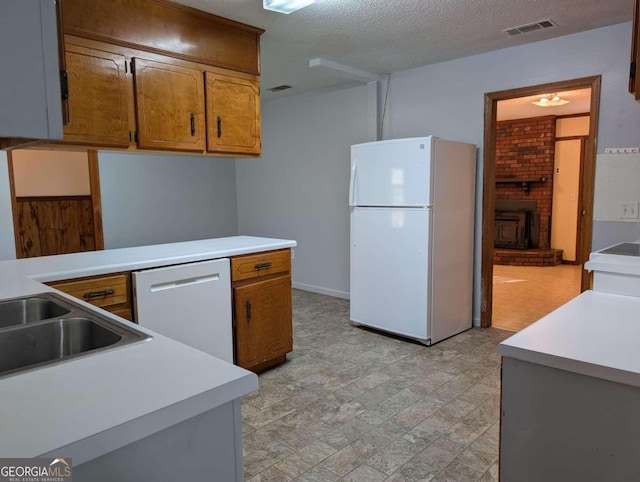 kitchen featuring a textured ceiling, a fireplace, and white appliances