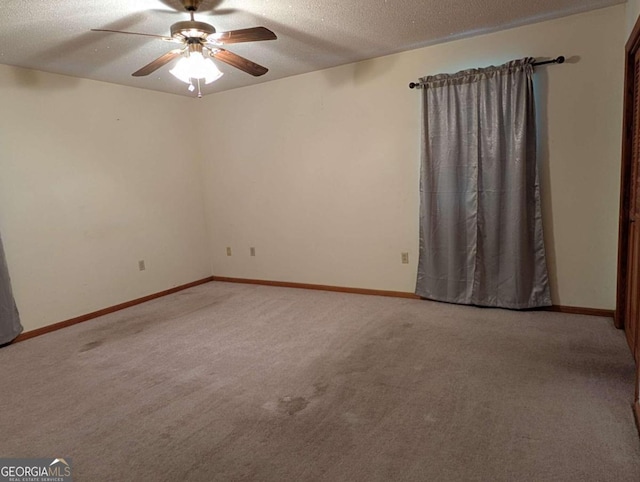 carpeted spare room with ceiling fan and a textured ceiling