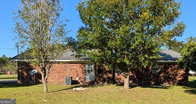 view of side of property with a yard and cooling unit