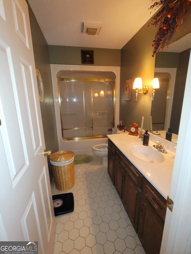 full bathroom with tile patterned floors, vanity, toilet, and enclosed tub / shower combo