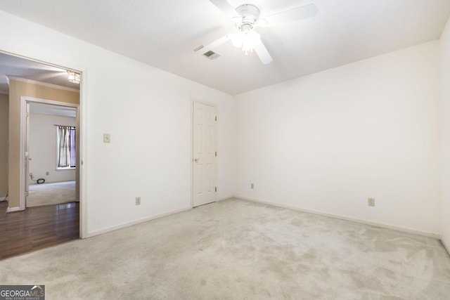 unfurnished room featuring carpet, visible vents, and a ceiling fan