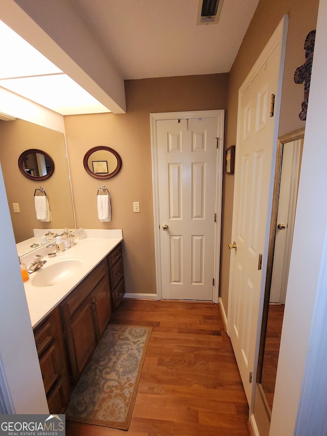 bathroom with vanity and wood-type flooring