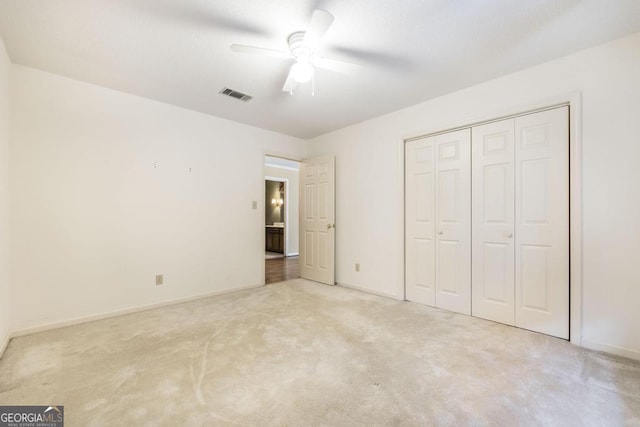 unfurnished bedroom with baseboards, visible vents, ceiling fan, carpet flooring, and a closet