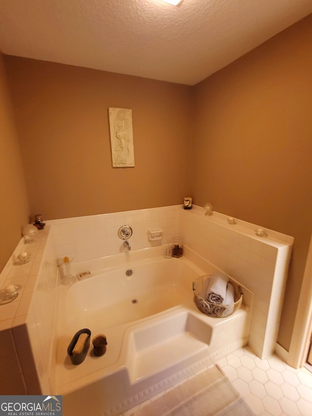 bathroom with a textured ceiling, tile patterned flooring, and a tub