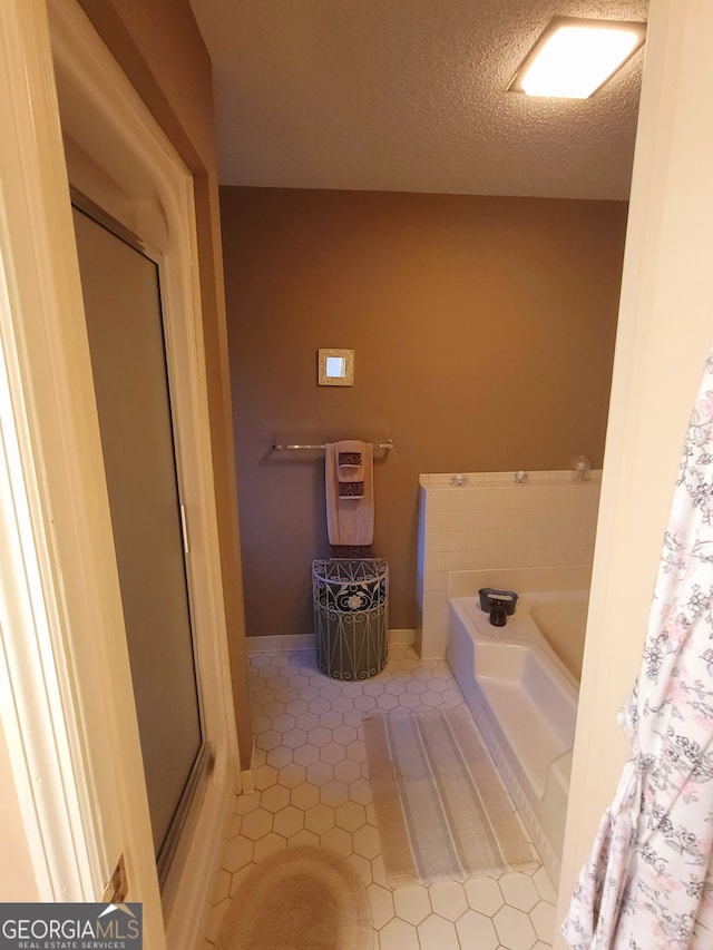 bathroom featuring tile patterned floors, a bathing tub, and a textured ceiling