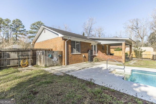 back of property with a fenced in pool, a patio, fence private yard, a yard, and brick siding