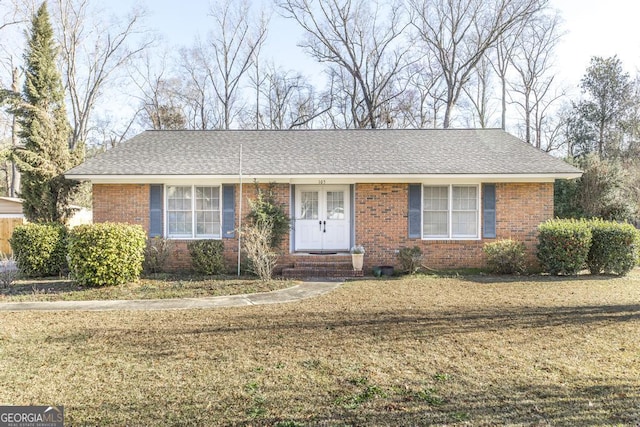 ranch-style house with brick siding, a front yard, and a shingled roof