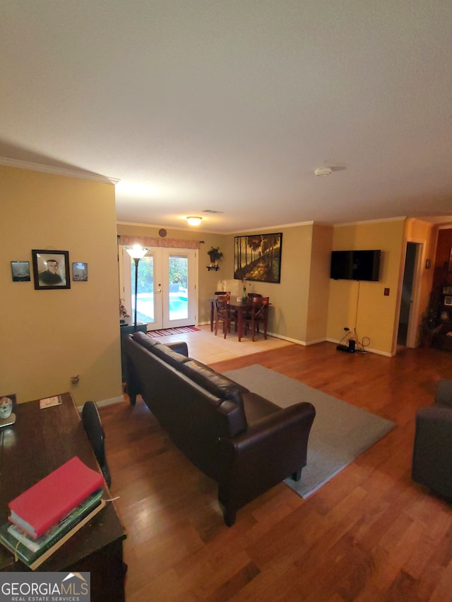 living room featuring french doors, hardwood / wood-style flooring, and ornamental molding