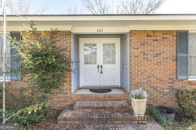 view of exterior entry featuring brick siding