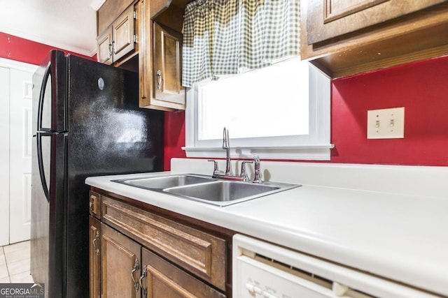 kitchen featuring dishwasher, light countertops, light tile patterned flooring, and a sink